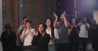 Çeşitli insan grupları ruhani bir toplantıda el çırpıyor, birlik ve inancın sevinçli bir şekilde kutlanıyor, etnik içerikli, ibadet sırasında toplum birbirine bağlanıyor.