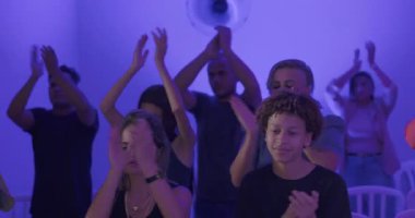 Mavili odada kilise ayini sırasında el çırpıp ruhani birlik içinde el çırpan ibadet edenler, yürekten övgüler ve adanmışlıkla bağlı olan gözleri kapalı insanlar.