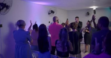 Cemaat, ruhani ayin sırasında vaiz ile yüzleşir. Durmaktan tapınmanın son yansıtıcı anlarında oturmaya geçiş yapar.