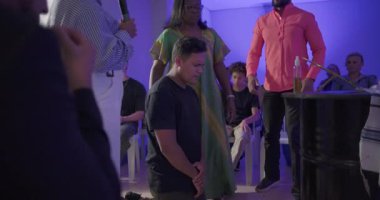 Kilisenin önünde diz çöküp dua eden genç bir adam vaiz ve cemaatin yakın ruhsal hizmet sırasında izlediği