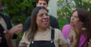 Heyecanla gülümseyen Latin bir kadın, arkadaş olarak daha fazla alkış istiyor. Açık havada tezahürat yapıyor, sevinç dolu bir tanınma ve kutlama anı.