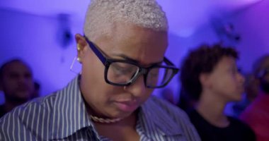 Düşünceli kilise ayini sırasında genç bir çocuk gülümsemesi ile başlarını eğip sessizce dua eder.