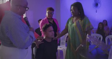 Erkek ve kadın, kilise ayini sırasında yoğun dua ve kutsama anlarında genç erkeklerin omuzlarına biner.