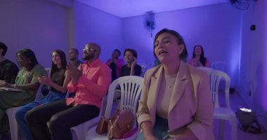 Çeşitli cemaatler aktif olarak kilise ayinine katılıyor. Önde sevinçle ibadet eden bir kadın. Diğerleri ise el çırpıyor ve küçük kapalı mekanlarda toplanıyor.