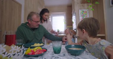 Ebeveynler aile yemeği sırasında çocuklarla etkileşim halinde, karşılama mutfağında yemek servisi ve paylaşımı, yetiştirme ve ebeveynlik bakımını vurgulayarak,.