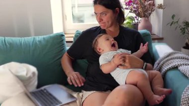 Anne kucağında bebek, çoklu görev, modern ebeveynlik, dengeleyici kariyer ve çocuk bakımı, ev ofisi, sorumluluk, iş hayatı dengesi, güvenlik.