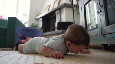 Bebek mindere uzanıyor, ağzı ile zemin araştırıyor, çocukluk gelişimi, duyusal keşif, bebek göbeği, ev ortamı, büyüyen farkındalık.