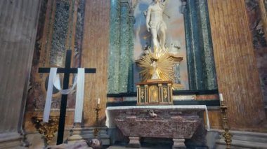 Roma, İtalya, 29 Temmuz 2025 - Tarihi Roma 'daki Agone Kilisesi' ndeki sunağın yanında siyah ahşap haçlı ve beyaz kumaşlı yalancı İsa heykeli.