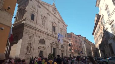 Roma, İtalya, 30 Temmuz 2025 - Roma 'daki Loyola Kilisesi' nin dışında heykeller, İtalyan ve Avrupa bayrakları ve açık gökyüzü altında kalabalık bir cadde