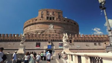 Roma, İtalya, 30 Temmuz 2025 - SantAngelo Kalesi 'ne yaklaşan turistler, açık bir gökyüzünün altında melek heykelleri ve tarihi kale duvarlarıyla Ponte SantAngelo' dan geçiyorlar..