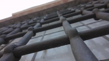 Vatikan 'ın tarihi penceresinde metal parmaklıkların aşırı düşük açısı perspektif ve mimari ayrıntıları vurguluyor