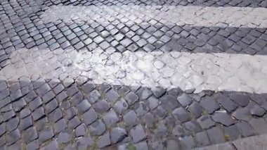 Roma, İtalya 'da beyaz çizgili ıslak kaldırım taşı kaldırımları, tarihi kentsel sokak tasarımı ve Avrupa mirası şehir dokusu sergileniyor.