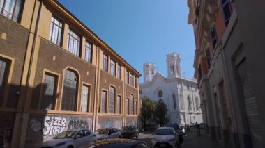 Roma, İtalya, 30 Temmuz 2025 - Roma 'da ikametgah ve tarihi binalarla çevrili ikiz kuleleri olan beyaz bir kiliseye giden dar kentsel cadde