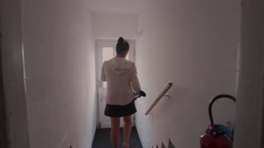 Anne kucağında küçük bir çocukla kapıyı açar. Büyük çocuk arkadan takip eder. Aile sabah evden çıkarken birlikte dışarı çıkar.