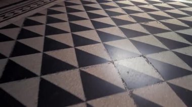 Geometrik siyah ve bej döşemeleri üçgen şekilli ve sınır detayı ile tekrarlayarak arka plan ve iç mekanlar için simetrik bir soyut mozaik oluşturur