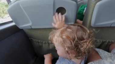 Yeni yürümeye başlayan çocuk, seyahat ederken otobüs koltuklarının arasına saklanmak için eğilir, başını koltuk cebine koyar ve çocuğun etrafında yetişkinler olur.