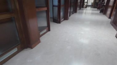 Beyaz mermer döşeme ve ahşap kaplama, dekoratif vazolar ve mobilyalar ile zarif koridor klasik iç mekanda derinlik, lüks ve simetri hissi yaratıyor.