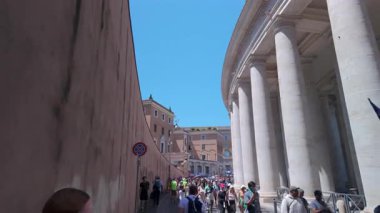 Roma, İtalya, 30 Temmuz 2025 - Açık bir yaz günü Roma 'da, Vatikan Duvarı' nda, Saint Peters Meydanı 'nın yanında, parlak giysili hacılar yürüyüş yapıyor..