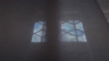 Odaklanamayan geometrik pencere deseni, dağınık mavi ve kırmızı ışığı, soyut kompozisyonda renk ve yapıyı harmanlayarak perdenin içinden geçirir.