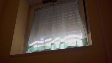 Saf perdeli iç pencerenin yukarı görünümü, gündüz vakti filtrelenen güneş ışığı