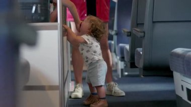 Küçük çocuk ağlarken, ağlayan ağabey trenin içindeki kavga, duygusal kardeş çatışması ve toplu taşımacılıkta aile içi gerginlik sırasında yüzünü uzaklaştırıyor.