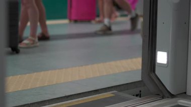 Tren istasyonu platformu boyunca bavulla yürüyen yolcular, toplu taşıma, hareket, turizm, seyahat ve kentteki günlük yolculuğu temsil eden kentsel seyahat sahnesi