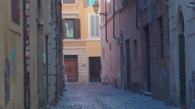 Pencereleri kapalı yüksek tarihi binalar arasında dar kaldırım taşlı dar bir ara sokak, Avrupa 'nın sonundaki caddenin güneşli cephesine açılıyor
