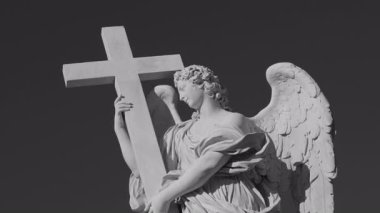 Roma, İtalya, 30 Temmuz 2025 - Tek renkli Ponte SantAngelo üzerinde haç taşıyan melek heykeli, barok mermer heykel Hıristiyan sadakati ve inancını simgeliyor
