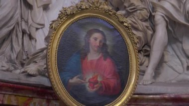 Roma, İtalya, 30 Temmuz 2025 - Bazilika içindeki mermer yardım heykellerinden önce İsa 'nın Kutsal Kalbi' nin çerçeveli resminin yakın çekimi