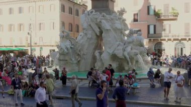 Roma, İtalya, 30 Temmuz 2025 Piazza Navona 'daki Dört Nehir Çeşmesi' nin etrafında toplanan kalabalık barok heykellere hayran ve canlı şehir atmosferinin tadını çıkarıyor.