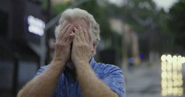 Yüzü tamamen yağmura bulanmış yaşlı bir adam duygusal çöküntü ya da çaresizlik anlarını ifade ediyor.