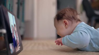 Video çağrısı sırasında bebek izleme tableti, heyecan ve merakı gösteriyor, büyükanne ve büyükbabayla dijital etkileşim, ekran yoluyla erken sosyal etkileşim