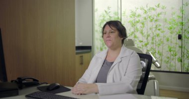 Klinikte tıbbi konsültasyon sırasında kadın doktoru dinleyen yaşlı erkek hastaya dikiz bakış açısı, bulanık bir geçmişe sahip sağlık ortamında güven ve iletişim