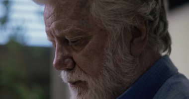 Profilde yaşlı bir adam derin düşüncelere dalmış, düşünceli ve sakin bir ortamda duygusal derinlikle işaretlenmiş.