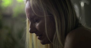 Tedavi sırasında üzüntüden yere bakan bir kadın. İfadesinde görülen duygusal gerginlik. Hastanede derin düşüncelere daldığı bir an.