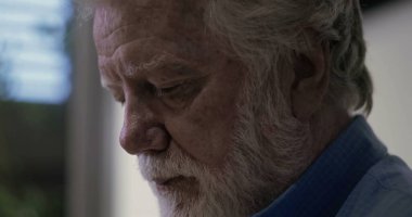 Profilde yaşlı bir adam derin düşüncelere dalmış, düşünceli ve sakin bir ortamda duygusal derinlikle işaretlenmiş.