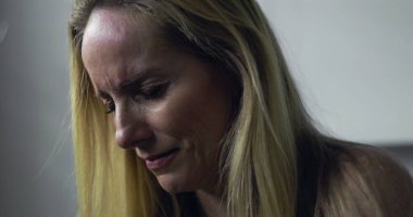 Acı dolu ifade ve kapalı gözlerle kadının yakın çekimi, tedavi sırasında duygusal an veya tıbbi sette teşhis