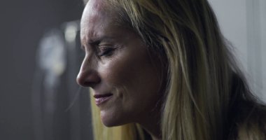 Acı dolu ifade ve kapalı gözlerle kadının yakın çekimi, tedavi sırasında duygusal an veya tıbbi sette teşhis