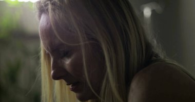 Tedavi sırasında üzüntüden yere bakan bir kadın. İfadesinde görülen duygusal gerginlik. Hastanede derin düşüncelere daldığı bir an.