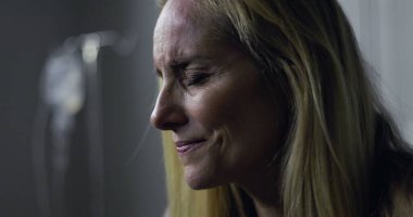 Acı dolu ifade ve kapalı gözlerle kadının yakın çekimi, tedavi sırasında duygusal an veya tıbbi sette teşhis