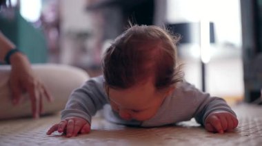 Bebek paspasın üzerinde yatıyor, yüzeye ve ellere bastırıyor, dokunsal keşif, dokuyu keşfetme, erken duyusal öğrenme, motor beceriler geliştirme, huzur dolu ev ortamları.