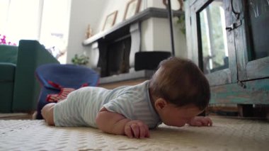 Bebek mindere uzanıyor, ağzı ile zemin araştırıyor, çocukluk gelişimi, duyusal keşif, bebek göbeği, ev ortamı, büyüyen farkındalık