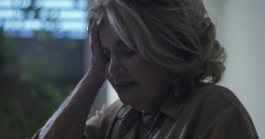 Yaşlı kadın el ele dinleniyor, gözleri duygusal yorgunluk anında kapalı ya da iç çan kulesinde.