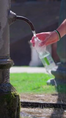 Elle doldurulan plastik şişede halka açık havuzdan içme suyu, su ve serinletici içecekler var.