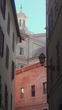 Geleneksel Roma binaları ve kırsal mimari cephelerin üzerinde haç yükselen katedral kubbesinin tarihi sokak manzarası