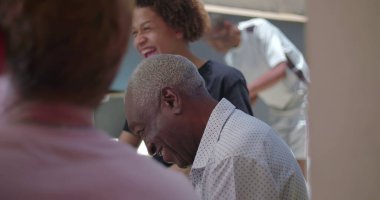 Yaşlı bir adam açık havada barbekü yaparken ailesiyle samimi bir anın tadını çıkarıyor. Çoklu kuşak bağları ve arka bahçede gelişigüzel toplanma.