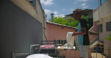 Latin Amerika 'nın sıradan bir arka bahçesinde barbekü hazırlıklarına odaklanmış bir zenci.