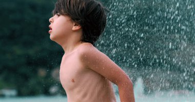 Suyun tadını çıkaran bir çocuk, yaz oyununun coşkusunu ve heyecanını gözler önüne seriyor, 800 fps 'de yavaş çekim görüntüsü.