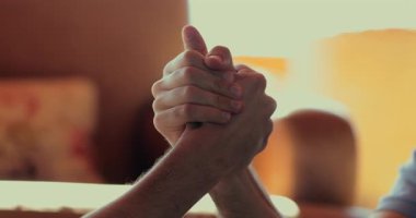 Kapalı alanda bilek güreşi yapan iki adam, sıkıca kavrama gücü, meydan okumayı, kararlılığı ve yakın çekim dinamik çekimde erkek rekabetini simgeleyen eller.