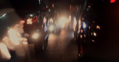 Geceleri yoğun trafik sıkışıklığı vardı. Arabalar tampon tampona dizilmişti. Yağmurlu şehir trafiğinde parlayan ve bulanık farlar vardı.